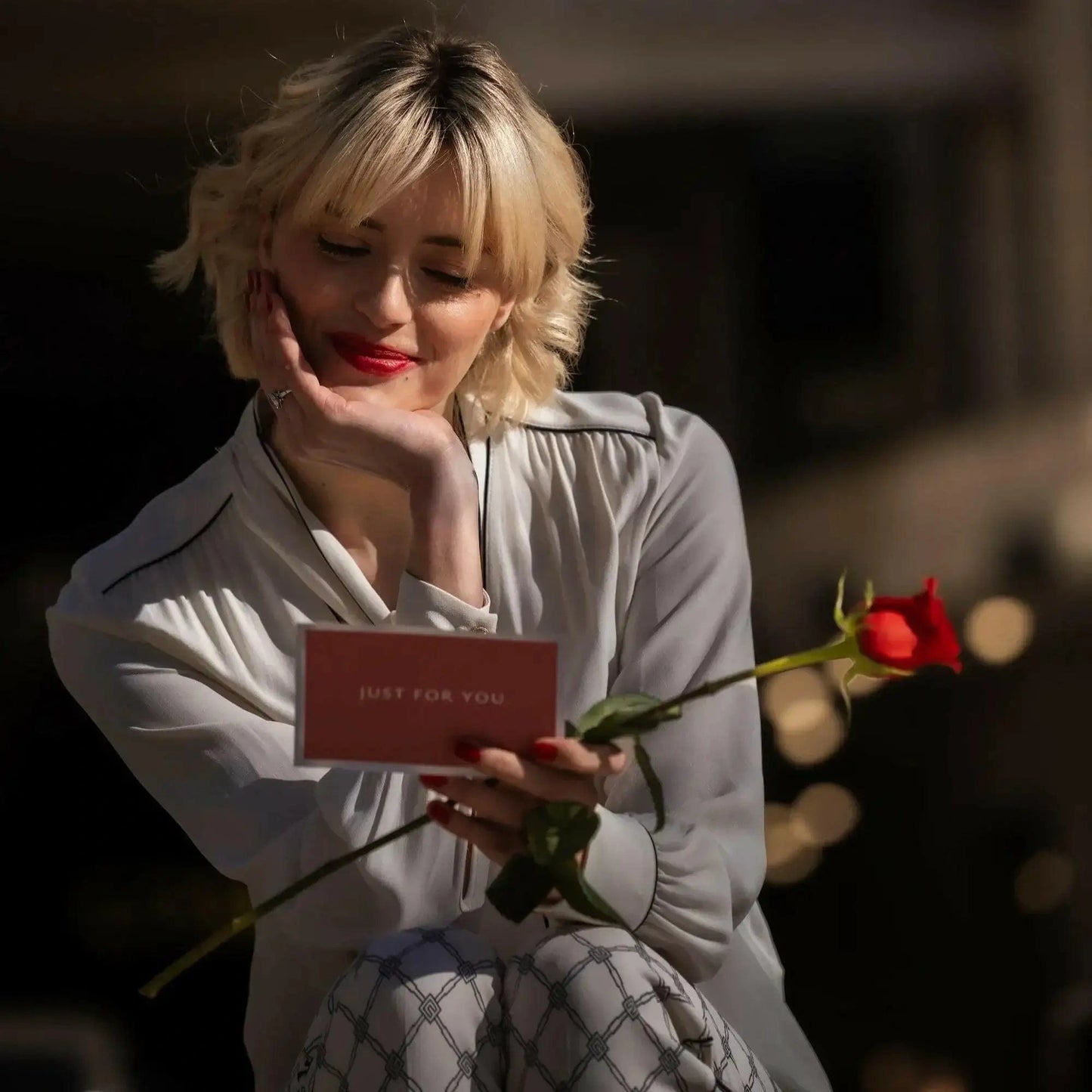 Buquê de Rosas Vermelhas e Chocolates Arcádia modelo a ler cartão just for you e sorriso  | QRoses